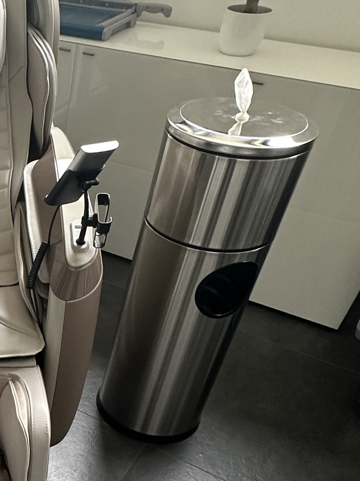 
Hygienestation aus Edelstahl neben einem Massagesessel, oben schaut ein Tuch aus dem Spender